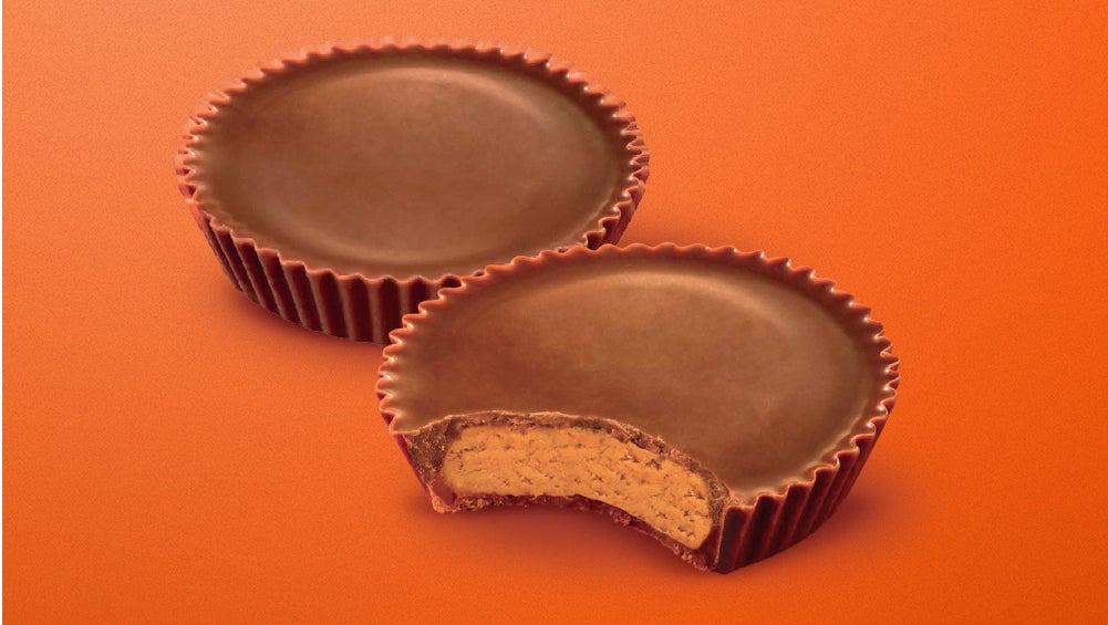 Par de chocolates Reese's, el Reese's de enfrente se encuentra mordido.