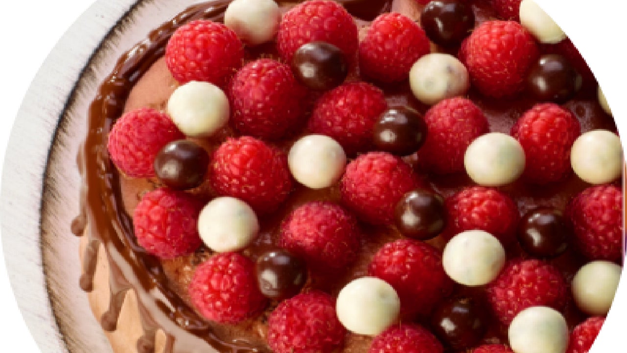 Pastel de Chocolate decorado con frambuesas y bolitas de Chocolate blanco.