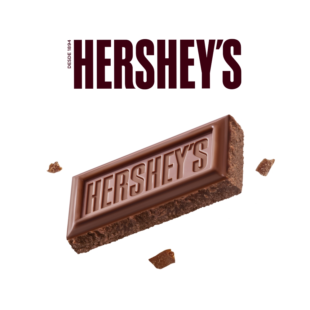 HERSHEY'S Bites Cookies n' Creme 43 g sobre un fondo color azul. Sobre el fondo se observan trozos de galletas y HERSHEY'S Bites Cookies n' Creme. 